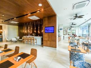 a restaurant with tables and chairs and a tv on a wall at Unique (Ex-Estanconfor) veja o mar do apto 1706 in Santos