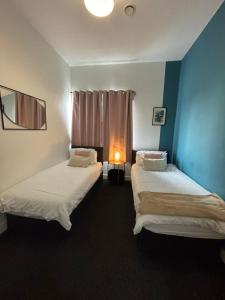 two beds in a room with a window at Propti in Manchester