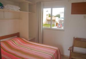 a small bedroom with a bed and a window at Mirante dos Ingleses in Florianópolis