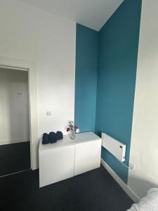 a room with a blue wall and a white desk at Propti in Manchester