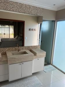 a bathroom with a sink and a mirror at CASA OUTEIRO da GLORIA in Porto Seguro