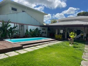 a backyard with a swimming pool and a house at CASA OUTEIRO da GLORIA in Porto Seguro +16 photos
