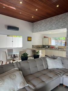 a living room with a couch and a kitchen at CASA OUTEIRO da GLORIA in Porto Seguro