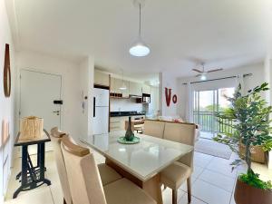 a kitchen and dining room with a table and chairs at Apartamento com VISTA MAR, Ar-condicionado, Wi-Fi Condomínio com PISCINA, quadra de esportes Playground infantil a 15 minutos do Beto Carreiro in Piçarras +27 photos