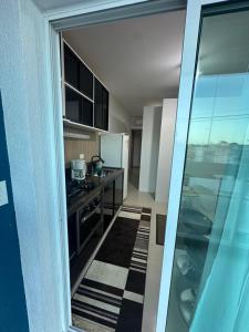 a kitchen with a stove and a refrigerator at Marcial Guest House - Caioba in Matinhos