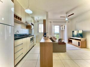 a large kitchen with white cabinets and a counter top at Apartamento com VISTA MAR, Ar-condicionado, Wi-Fi Condomínio com PISCINA, quadra de esportes Playground infantil a 15 minutos do Beto Carreiro in Piçarras