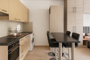 a kitchen with a black table and black chairs at Maison Amalthea in Limassol