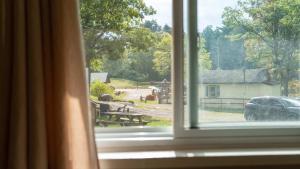 an open window with a view of a house at 2-Bedroom Cottage #5 - Lodgepole Pine in Gravenhurst