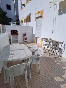 ein weißer Tisch und Stühle auf einer Terrasse in der Unterkunft CASA DA PRAIA DA POÇA - Apartamento Rosa in Estoril