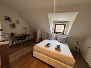 a bedroom with a bed with a window and a desk at Guest house Time to Escape in Meise