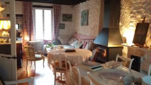 a living room with a table and chairs and a living room at L'Envolée in Belvianes-et-Cavirac