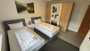 a hotel room with two beds and a bathroom at Exklusive Wohnung für 8 Personen mit großem Balkon in Niestetal