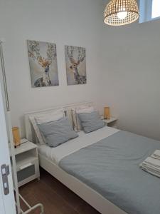 ein Schlafzimmer mit einem Bett und zwei Bildern an der Wand in der Unterkunft CASA DA PRAIA DA POÇA - Apartamento Rosa in Estoril