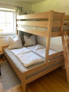 a bunk bed with white pillows on it at Ferienwohnung Schmied in Ebersberg