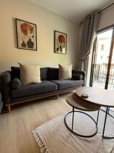 サイモンズタウンにあるMountain Bay Apartment with Sea and Mountain Viewsの黒いソファとテーブルのあるリビングルーム