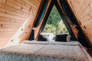 a bed in a room with a large window at Kuća za odmor Kiara - bazen, jacuzzi i sauna in Karlovac +93 photos
