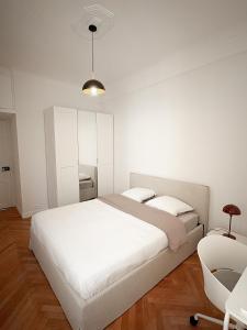 a white bedroom with a bed and a chair at Nice Center - Spacious Luxury Apartment with Air Conditioning in Nice