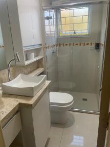 a bathroom with a shower and a toilet and a sink at AP prox Unisinos-Trem com 2 AC e 2 smart TV in São Leopoldo