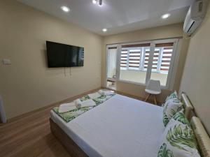 a bedroom with two beds and a flat screen tv at Bohemi Apartment in Ruse