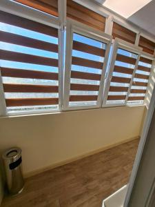 a room with three windows with wooden shutters at Bohemi Apartment in Ruse