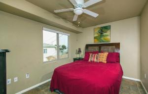 a bedroom with a red bed with a ceiling fan at Three Bedroom Beachfront Condo in San Diego in San Diego