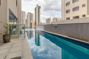 a swimming pool in a city with tall buildings at RBN - Apartamentos no Ritmo Bueno in Goiânia