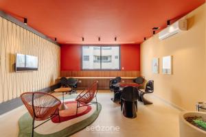 a waiting room with chairs and tables and a window at RBN - Apartamentos no Ritmo Bueno in Goiânia