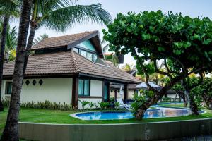 a house with a swimming pool in front of it at Bangalô c/ Piscina - Marulhos Resort, Beira Mar de Muro Alto / Porto de Galinhas in Porto De Galinhas +29 photos