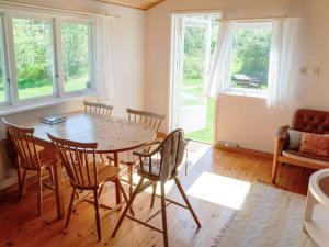 a dining room with a wooden table and chairs at 4 person holiday home in Tyresö in Tyresö +17 photos