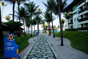 a walkway next to a resort with palm trees at Bangalô c/ Piscina - Marulhos Resort, Beira Mar de Muro Alto / Porto de Galinhas in Porto De Galinhas