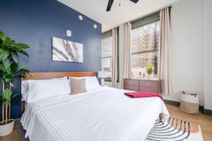 Un dormitorio con una cama blanca y una pared azul. en Cozy 1BR Downtown Birmingham, en Birmingham