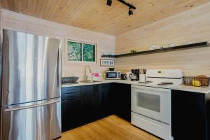 eine Küche mit einem Kühlschrank aus Edelstahl und Holzwänden in der Unterkunft Georgian Bay Rockwood 3-bdrm Waterfront Cottage #2 in Dillon