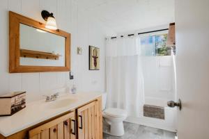 ein Badezimmer mit Waschbecken, Toilette und Spiegel in der Unterkunft Georgian Bay Rockwood 3-bdrm Waterfront Cottage #2 in Dillon