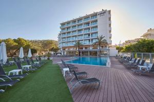 ein Hotel mit Stühlen, einem Pool und einem Gebäude in der Unterkunft Hotel Abrat in Sant Antoni de Portmany