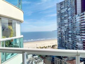 a balcony with a view of a beach and a building at Estanconfor Santos - vista mar in Santos