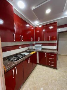 cocina con armarios rojos y fogones en Appartement T4, en Taza