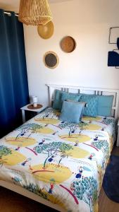 a bedroom with a bed with a colorful comforter at La Riviera - Site du Futuroscope - 3 chambres in Chasseneuil-du-Poitou