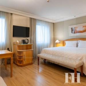 a hotel room with a bed and a television at Flat Higienópolis in Sao Paulo