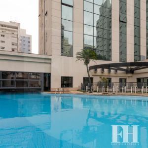 a large swimming pool in front of a building at Flat Higienópolis Premium in Sao Paulo