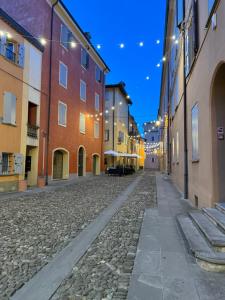 an empty street in a city at night at La Filanda Apartment in Castelvetro di Modena