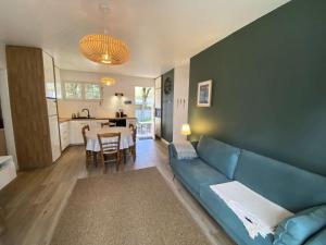 a living room with a blue couch and a table at Résidence 100-soulac Sur Mer - 100 - Charmante maison dans le quartier des Arros MAE-1951 in Soulac-sur-Mer