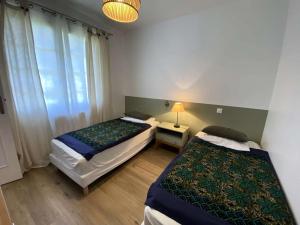 two beds in a small room with a window at Résidence 100-soulac Sur Mer - 100 - Charmante maison dans le quartier des Arros MAE-1951 in Soulac-sur-Mer