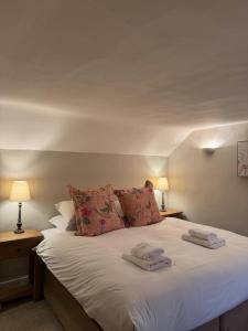 a bedroom with a bed with two towels on it at New Close Farmhouse in Bransgore