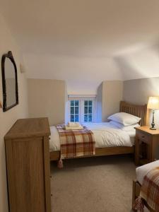 a bedroom with two beds and a window at New Close Farmhouse in Bransgore