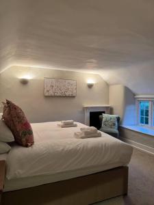 a bedroom with a large white bed and a chair at New Close Farmhouse in Bransgore