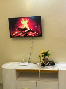 a tv on a wall with a fire in a fireplace at Ann'sbammyline Serene homes in Ruiru