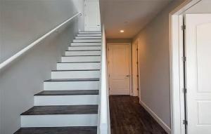 a staircase in a home with white walls and wooden floors at Four Bedroom Condo in North Hollywood in La Paco