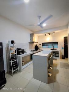 a large kitchen with a counter in a room at Carissa Homestay Kuantan in Kuantan