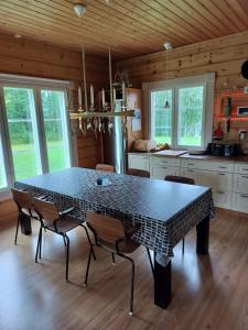 a kitchen with a table and chairs in a room at Villa Lehtoranta A touch of luxury on the lakeside in Rovaniemi