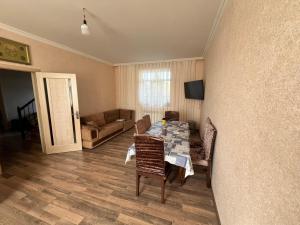 a living room with a table and chairs and a couch at Dubendi resort villa in Baku